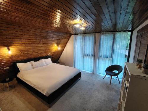 a bedroom with a bed and a wooden wall at Cabana A Brezoi in Brezoi