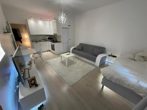 a living room with a bed and a kitchen at Smart 32m2 studio in a central location - Kallio in Helsinki