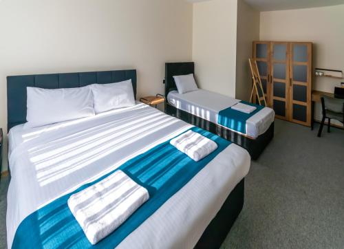 a hotel room with two beds and a desk at New Garden Airport Hotel in Arnavutköy