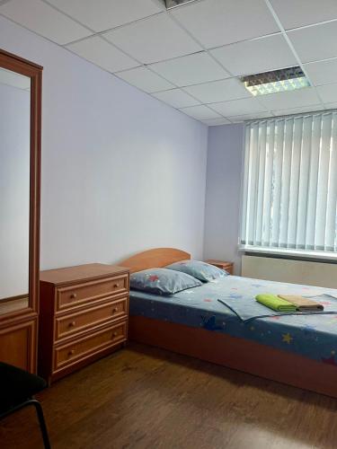 een slaapkamer met een bed, een ladekast en een raam bij Best4Rest in Kiev