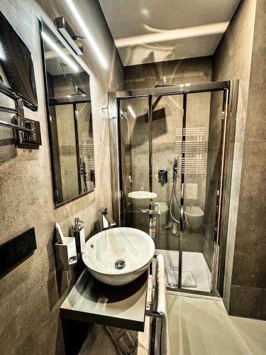 a bathroom with a sink and a shower at J Maluni City Hotel in Rome