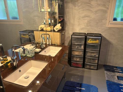 La salle de bains est pourvue de 2 lavabos et d'un comptoir avec des serviettes. dans l'établissement Belle Villa aux portes du Tarn, à Rabastens