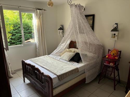 Cette chambre dispose d'un lit à baldaquin et d'une fenêtre. dans l'établissement Belle Villa aux portes du Tarn, à Rabastens
