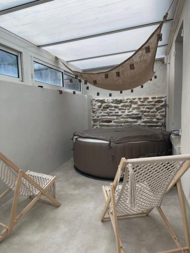 a room with a bed and a hammock in it at L R de la vallée in Fontenay-près-Chablis