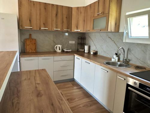 a kitchen with white cabinets and a wooden counter top at Nirvana in Tivat