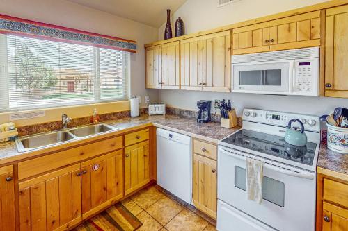 a kitchen with white appliances and wooden cabinets at Rim Village M4 in Moab