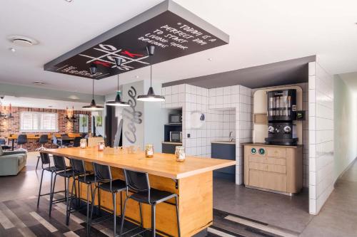 une cuisine avec une grande table et des chaises en bois dans l'établissement Student Factory Nice, à Nice