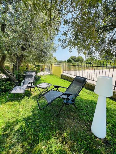 two chairs and a lamp in a yard with a fence at B&B Rifugio Degli Artisti - Themed Rooms in Monzambano