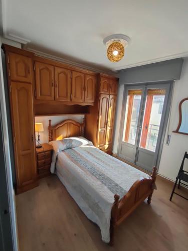 a bedroom with a large bed with wooden cabinets at Casa GLORIA in Ganuza