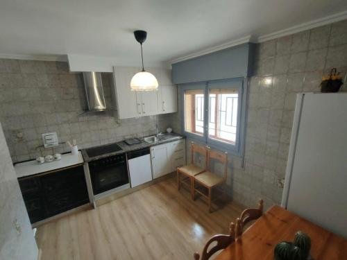 a kitchen with white cabinets and a table and a table sidx sidx sidx at Casa GLORIA in Ganuza