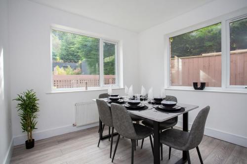 a dining room with a table and chairs and windows at The Burnopfield in Burnopfield