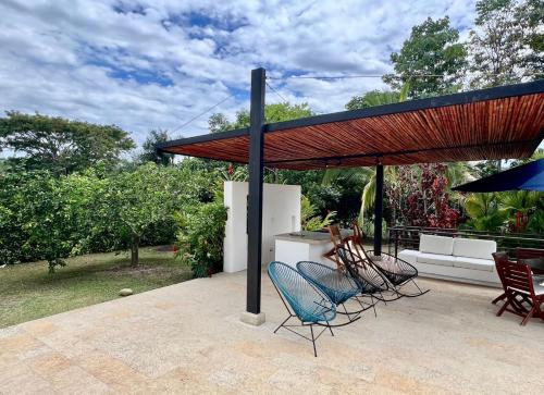 a patio with chairs and a red roof at Casa campestre Solé mediterranea con piscina en Anapoima in Anapoima