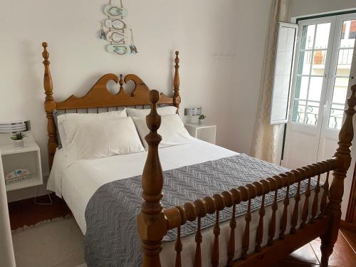 a bedroom with a large bed with a wooden headboard at Casa Do Gerardo in Nazaré