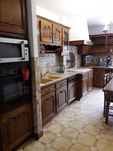 La cuisine est équipée de placards en bois, d'un évier et d'un four micro-ondes. dans l'établissement appartement 7 personnes, à Plombières-les-Bains