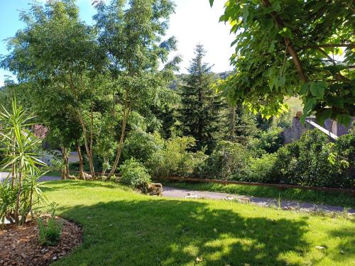 a yard with green grass and trees and a path at Bélénos - Suites & Spa in Bligny-sur-Ouche