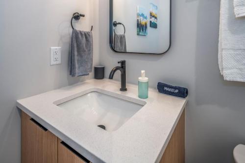 シンシナティにあるCentral Over-the-Rhine, 3 Lux Queen Beds, Steps to TQL, Findlay Market & Light Rail, Fast Wifi, Sleeps 7pplの白い洗面台と鏡のあるバスルーム