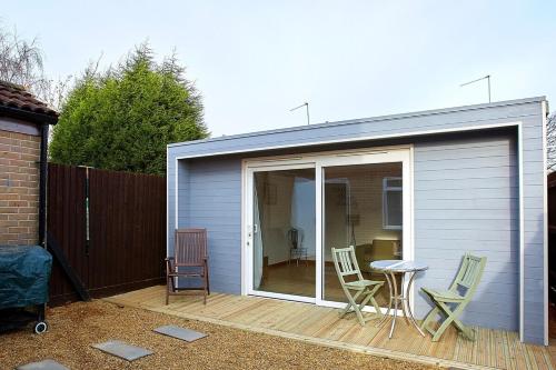 a garage with chairs and a table on a deck at Shirebrook House Coventry in Foleshill