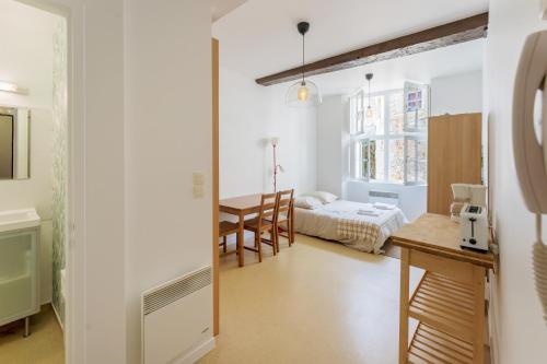 Habitación con 1 dormitorio, 1 cama y 1 mesa. en Charmant studio centre Bayonne, en Bayona