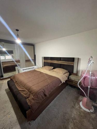 a bedroom with a large bed and a lamp at Cozy 1 bedroom apartment in Amman