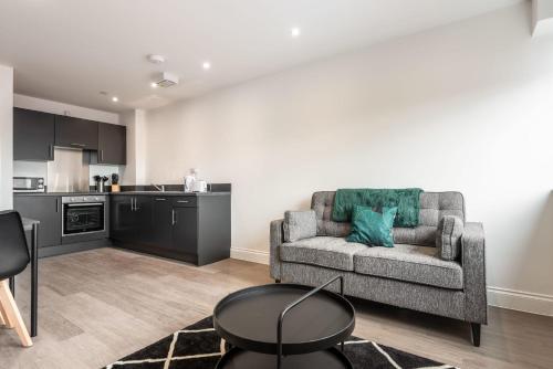 a living room with a couch and a kitchen at Modern 1 Bedroom Apartment in Central Wakefield in Wakefield