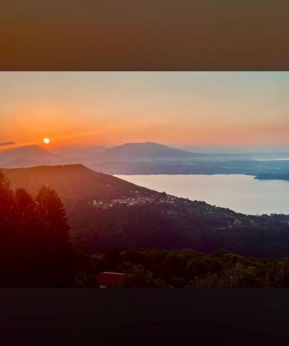 a sunset view of a city and a body of water at Il Sogno terrazza panoramica in Massino Visconti