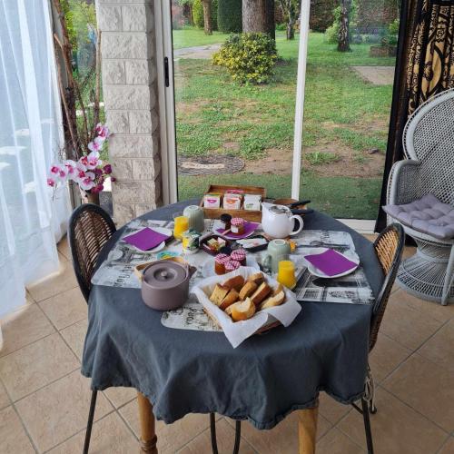- une table avec un plateau de pain, de jus de fruits et de jus d'orange dans l'établissement Les cèdres bleus, à Saint-Médard-de-Mussidan