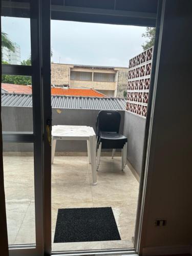 a door open to a patio with a table and a chair at Ape quadra do mar ao lado do Sesc in Matinhos