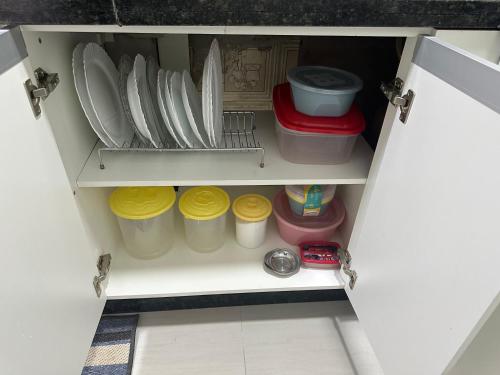 a cupboard with plates and other dishes in it at Ape quadra do mar ao lado do Sesc in Matinhos