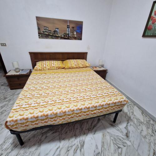 a bedroom with a bed with a yellow bedspread at Nuccia'S House in Reggio Calabria