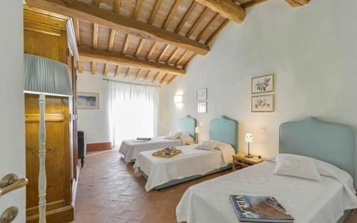 a bedroom with two beds in a room at Villa Lotus Magliano in Magliano in Toscana