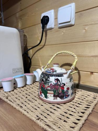 a tea pot sitting on top of a table at Cottage Keba-nikortsminda კოტეჯი ქება-ნიკორწმინდა in Ambrolauri