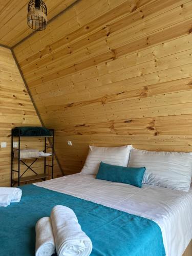 a bed in a room with a wooden ceiling at Cottage Keba-nikortsminda კოტეჯი ქება-ნიკორწმინდა in Ambrolauri