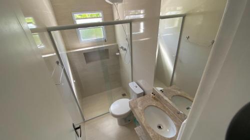 a small bathroom with a shower and a toilet at Pousada Pé na Areia Guarujá in Guarujá