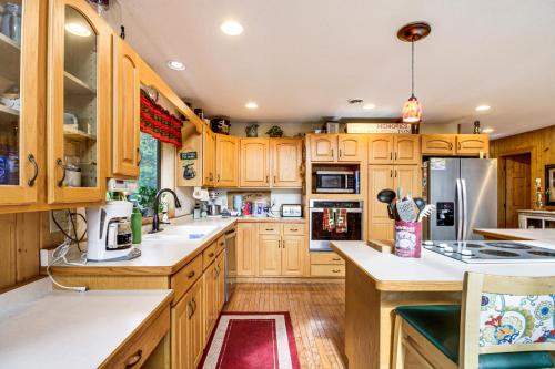 a kitchen with wooden cabinets and white counter tops at Idyllic Remer Cabin with On-Site Lake Access! in Remer