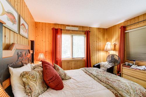 a bedroom with wooden walls and a bed with red pillows at Idyllic Remer Cabin with On-Site Lake Access! in Remer
