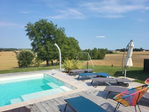 une piscine avec des chaises longues et un parasol dans l'établissement La Maison du Pouget, à Fénols