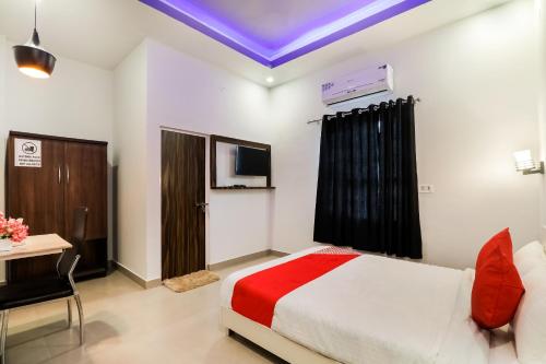 a bedroom with a bed and a desk and a tv at Collection O Sr Inn in Gomti Nagar