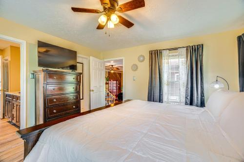 a bedroom with a large bed with a ceiling fan at Onalaska Home with Game Room, Sunroom and Lake View! in Blanchard