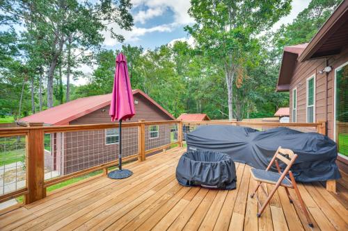 a patio with an umbrella and a chair on a deck at Onalaska Home with Game Room, Sunroom and Lake View! in Blanchard
