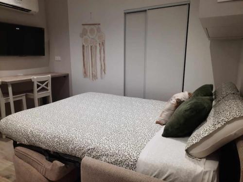 - une chambre avec un lit doté d'oreillers verts dans l'établissement Studio 3 - Appart' Hôtel tout confort avec balcon - TU ELLETA, à Tulette