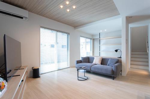 a living room with a couch and a television at -Mova Villa Koshi Misawa north-近阿蘇 熊本城 各類溫泉 台積電 合志獨棟民宿 體驗當地生活 in Yuge