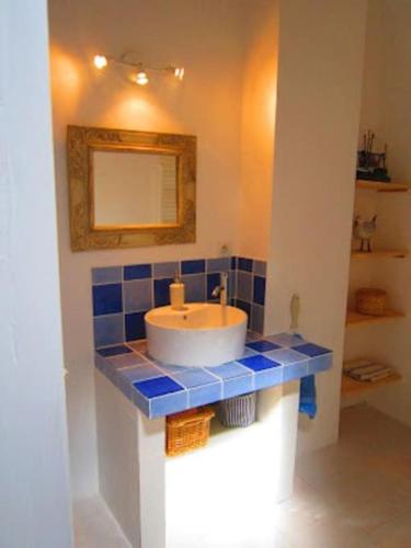 une salle de bain avec un lavabo et un miroir dans l'établissement Superbe maison de village et sa terrasse panoramique, à Oupia