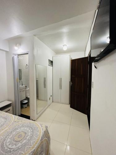 a bedroom with a bed and a bathroom with a mirror at Casa 4/4(Amplos), Cond. fechado com piscina-150m2 in Salvador
