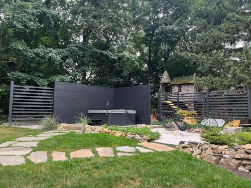 a backyard with a grill and a garden with grass at Ode to the '70's creative private home with pool in Honey Brook