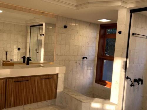 a bathroom with a sink and a shower at Naatooh Guest Houses in Florianópolis