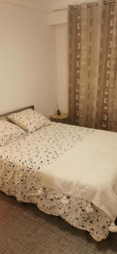 une chambre avec un lit avec une couette blanche dans l'établissement Appartement 3 pièces à 10 minutes de Cannes, au Cannet