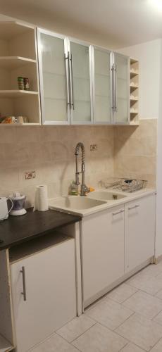 une cuisine avec des armoires blanches et un évier dans l'établissement Appartement 3 pièces à 10 minutes de Cannes, au Cannet