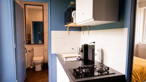 a kitchen with a sink and a coffee maker on a counter at Manoir des Carreaux Chambres d'hôtes in Ingouville