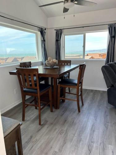 Smith RiverにあるOceanview Cabin 20, Private Jacuzzi &large Deckのダイニングルーム(テーブル、椅子、窓2つ付)