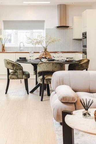 a living room with a table and chairs and a kitchen at Newly refurbished cosy 2 bed in Wembley in London